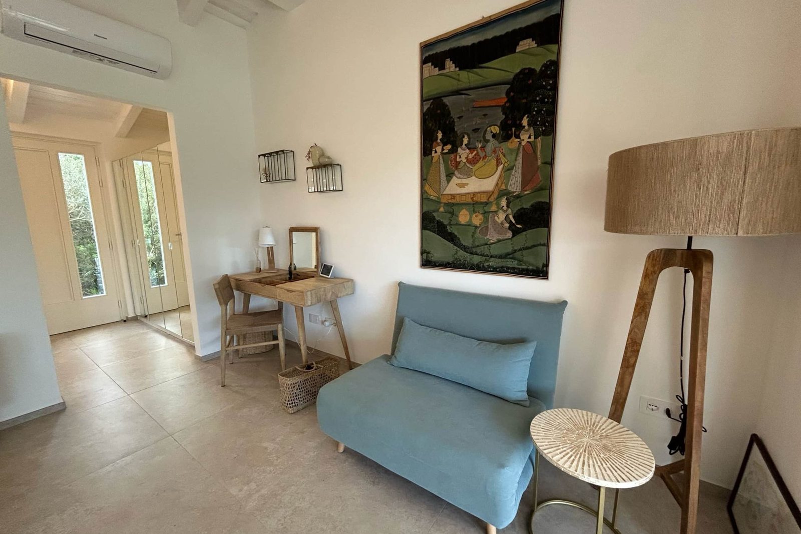 Camera Azzurra: angolo scrittoio con poltrona azzurra e lampada in rafia