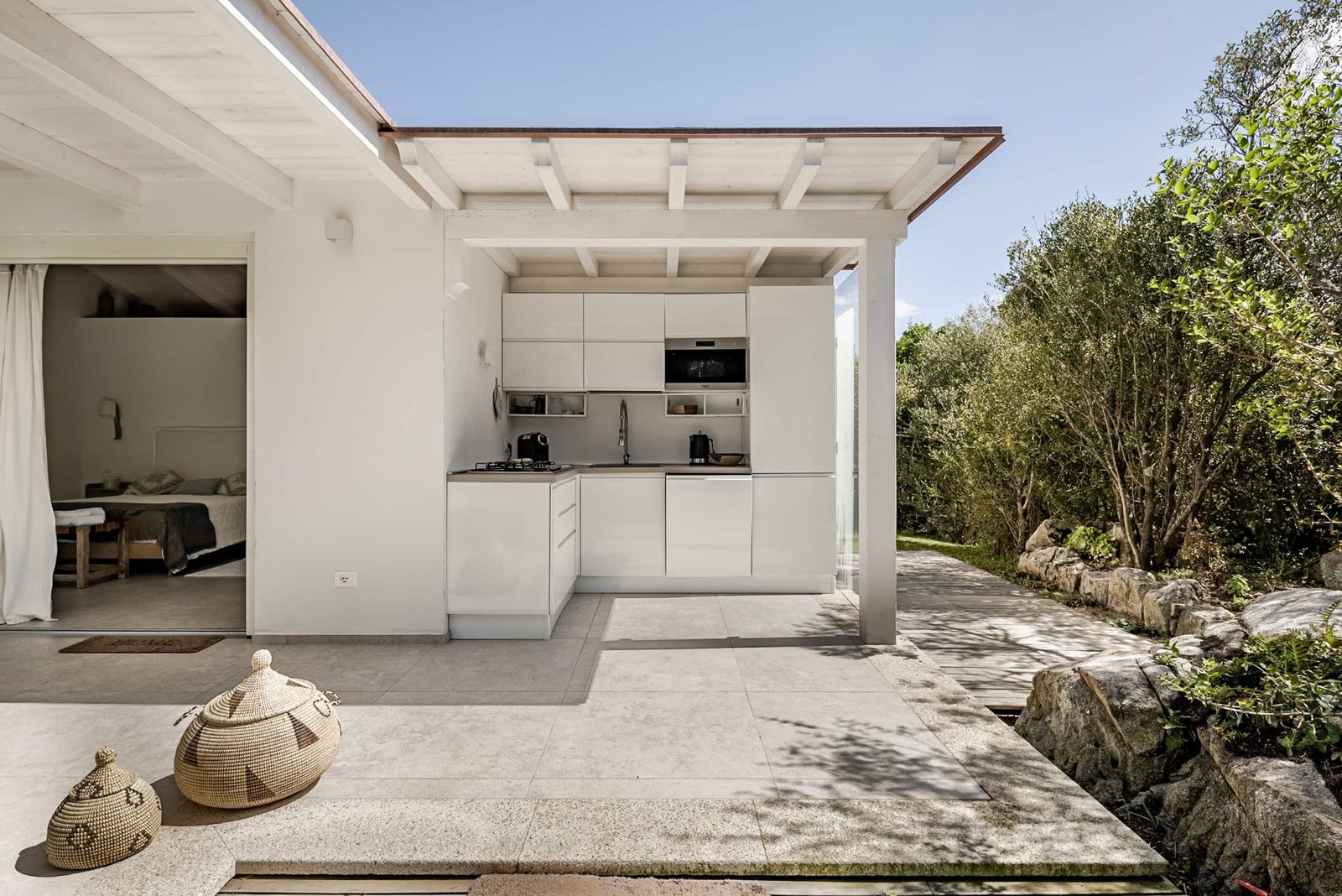 La cucina coperta vista dal giardino, con il piano cottura e il forno